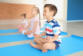 Little children practicing yoga indoors